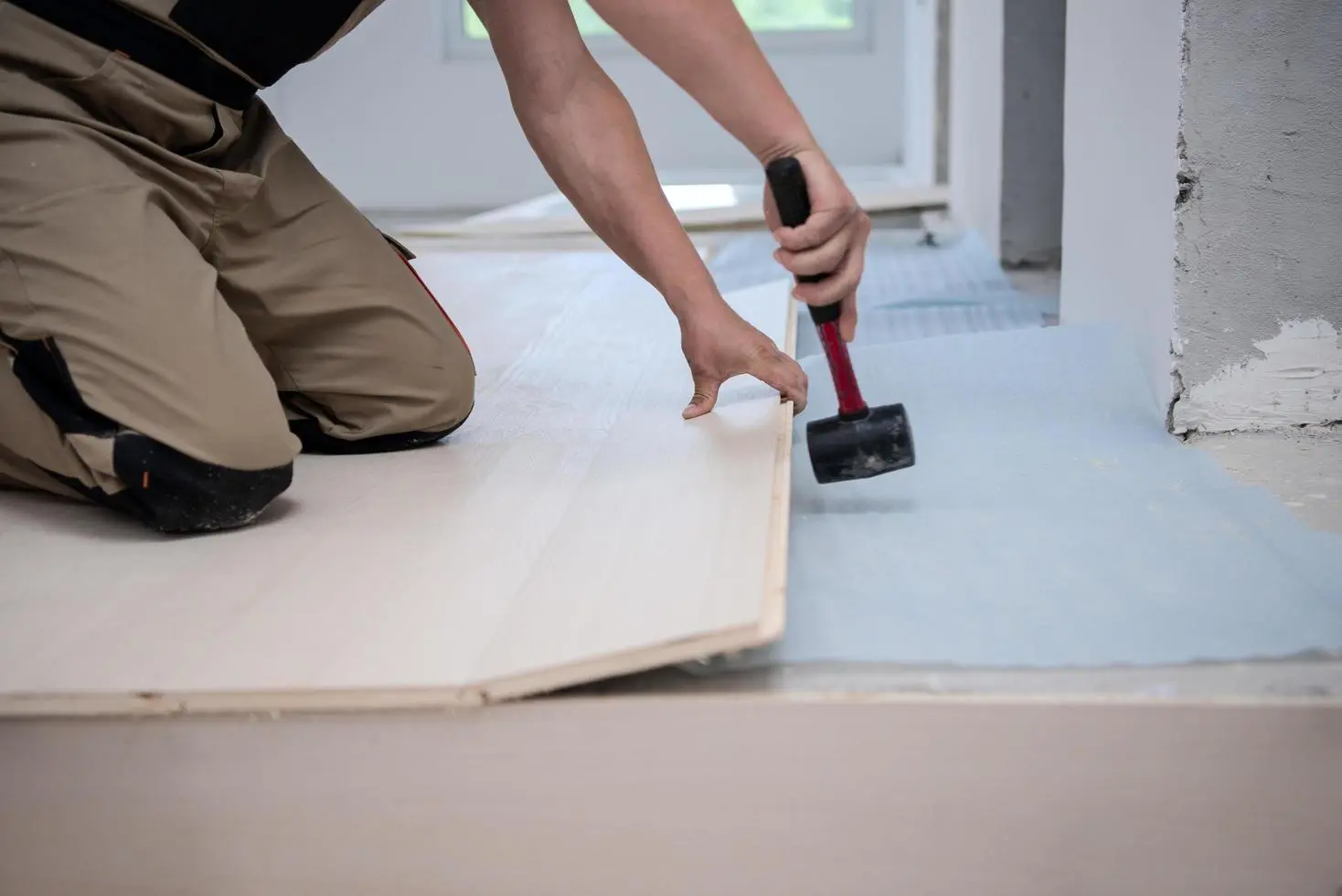 professional worker installing new laminated wooden floor